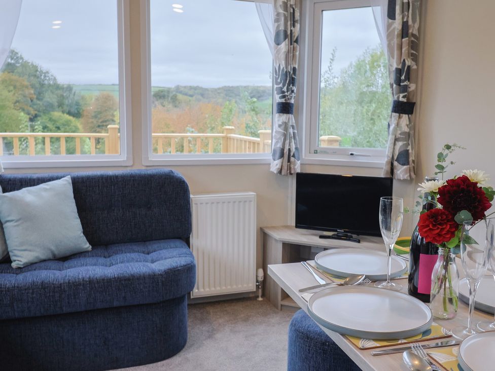 A living room with a couch and dining setup at caravan NEW Uplyme