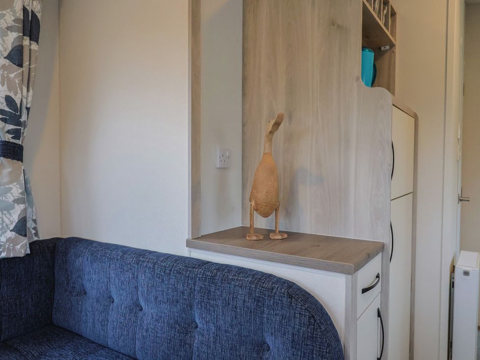 A living room with a sofa and wooden ornament at caravan NEW in Uplyme