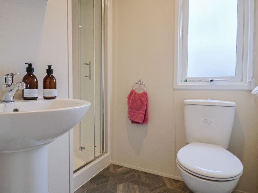 A bathroom with a sink, shower, and toilet at caravan NEW in Uplyme