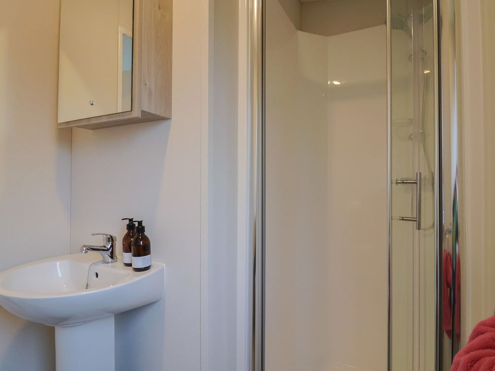 A bathroom with a sink and shower stall at caravan NEW Uplyme