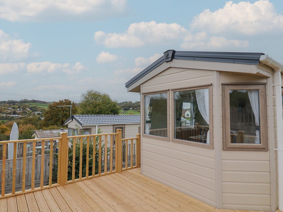 An outdoor area with a cabin and decking at caravan NEW in Uplyme