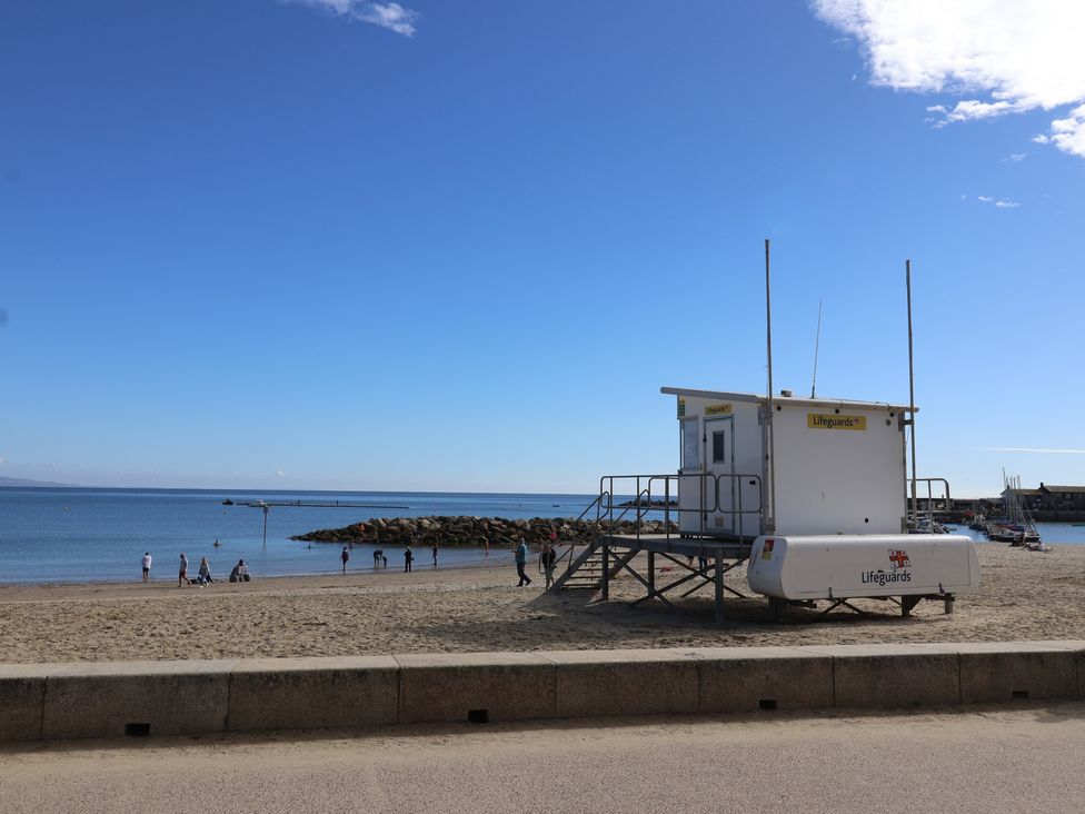 A lifeguard tower on the beach with people and ocean nearby at caravan NEW Uplyme