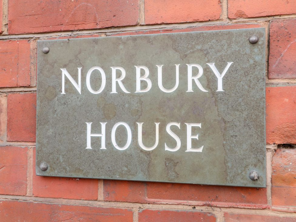 A plaque reading Norbury House on a brick wall at Norbury House