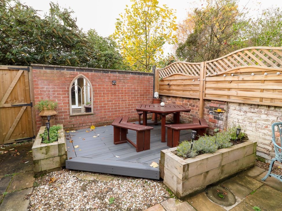 A garden with a wooden table and benches at Norbury House 
