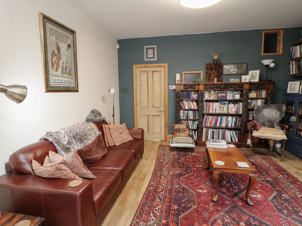 A living room with a sofa, bookshelf and table at Norbury House in Lincoln