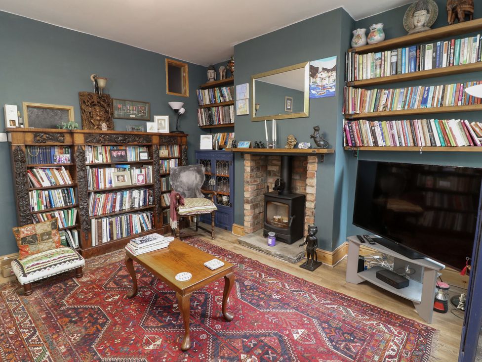 A living room with a bookshelf and fireplace at Norbury House in Lincoln