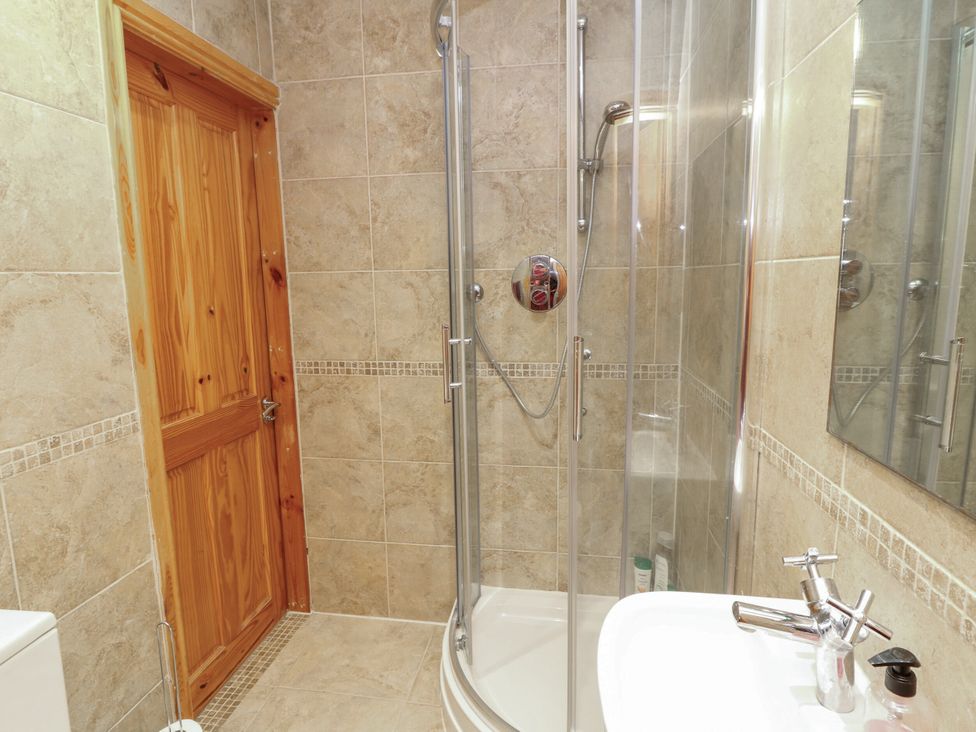 A bathroom with a shower, toilet, sink, and mirror at Norbury House in Lincoln