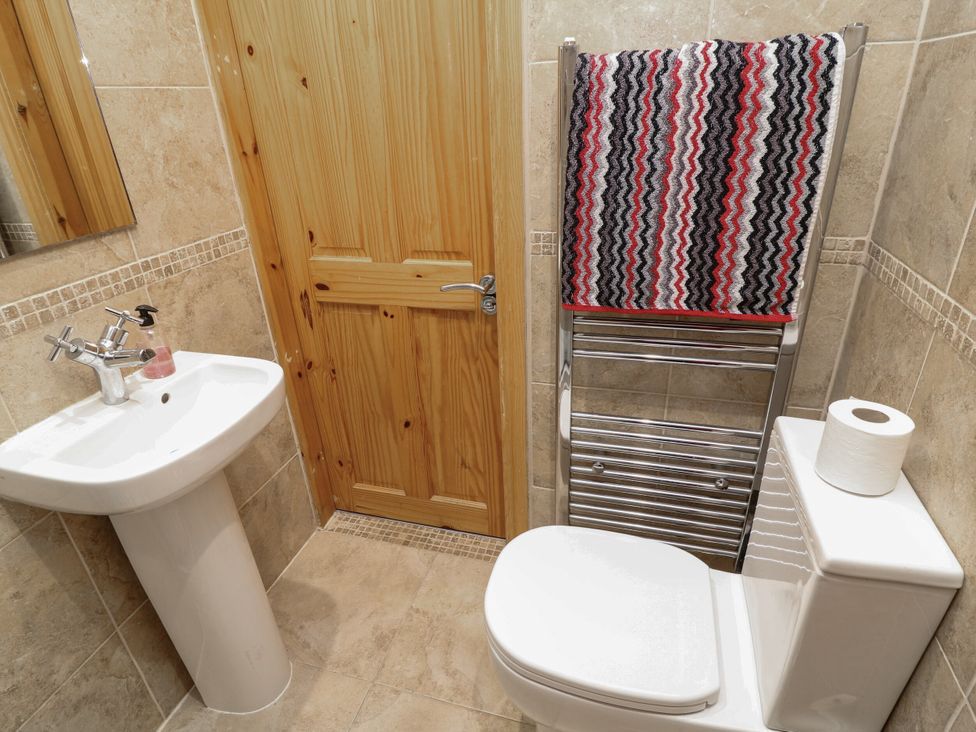 A bathroom with sink, toilet, and towel warmer at Norbury House in Lincoln