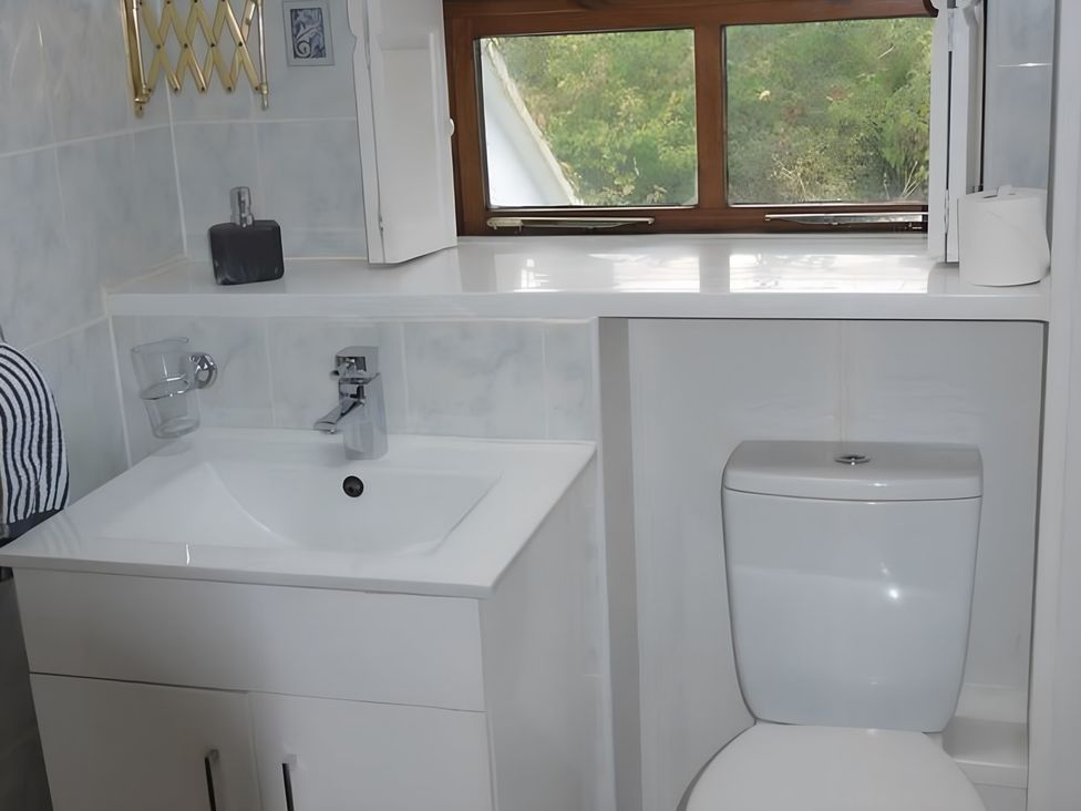 A bathroom with a sink and toilet at Tranquil Cottage 