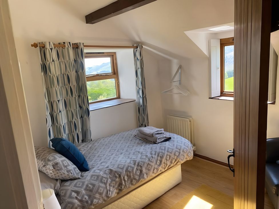 A bedroom with a bed and window at Tranquil Cottage 