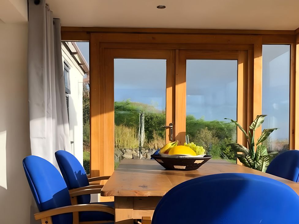 A dining room with a table and chairs at Tranquil Cottage