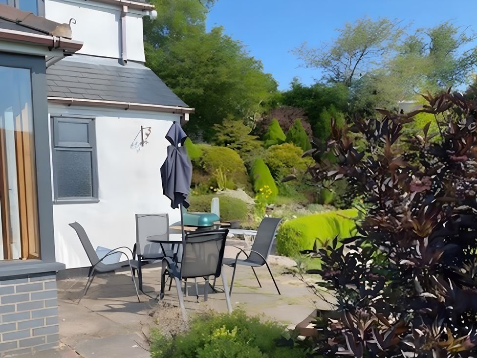 A garden with a table and chairs at Tranquil Cottage
