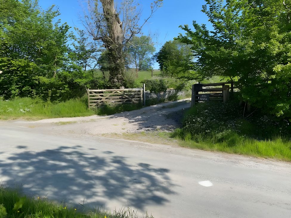 A gate and trees near a road at Tranquil Cottage in 