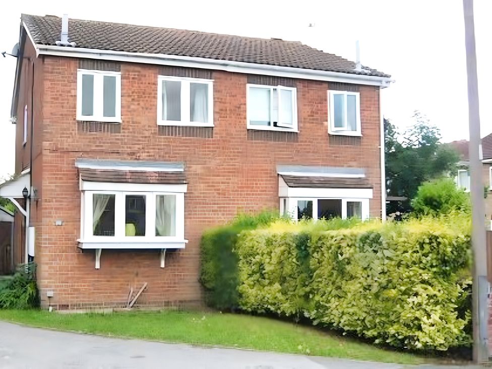 A house with windows and a hedge at 22 Homestead Garth