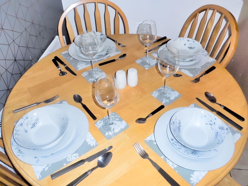 A dining table set with plates and glassware at 22 Homestead Garth