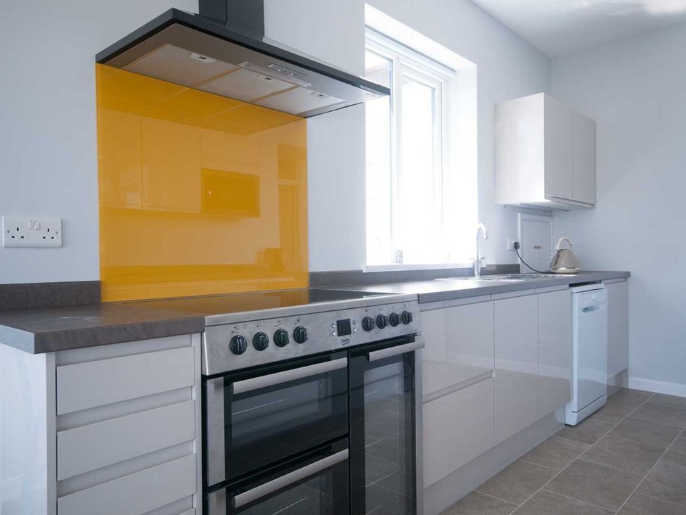A kitchen with cabinets and a stove at Chynoweth in Crantock
