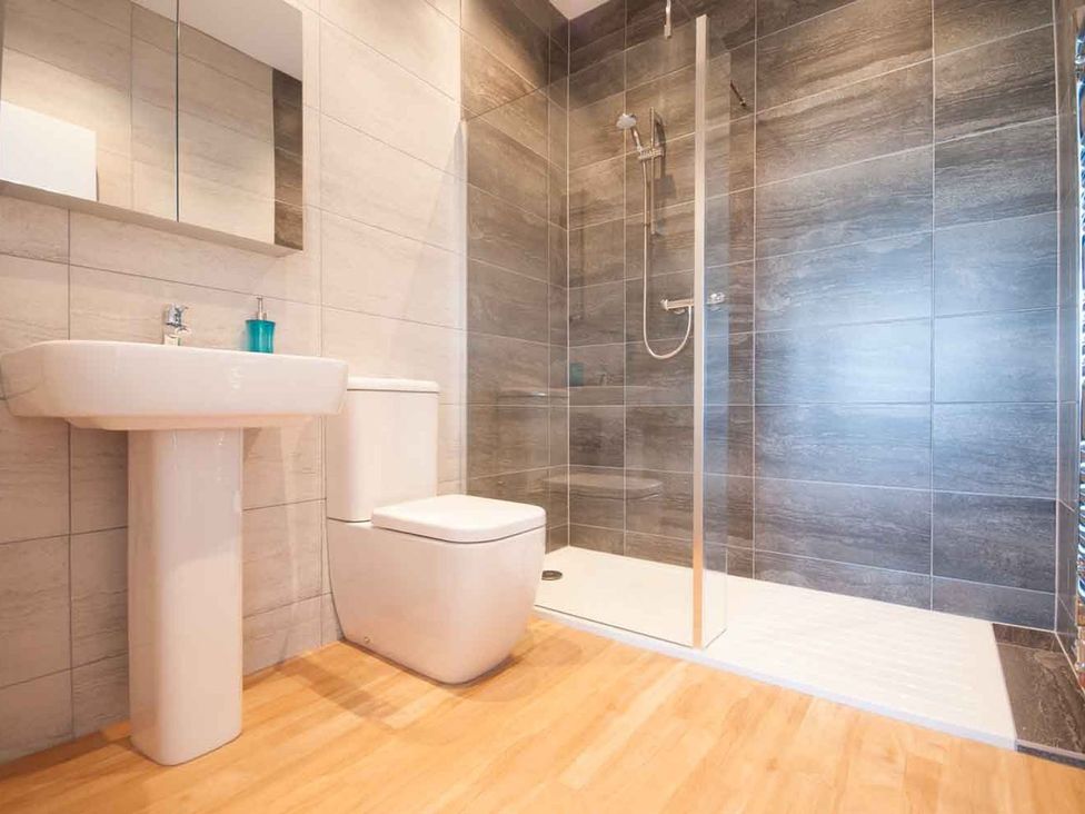 A bathroom with a sink, toilet and shower at Chynoweth in Crantock
