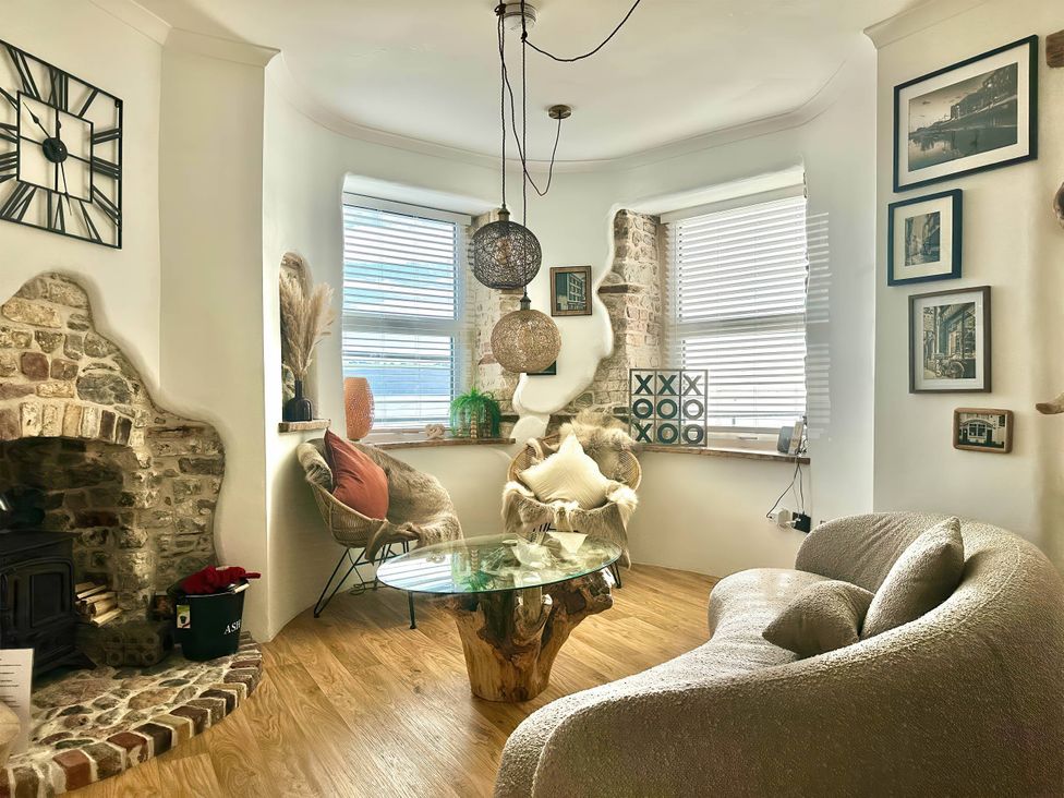A living room with a glass table and decorative elements at The Old Barn in Manchester