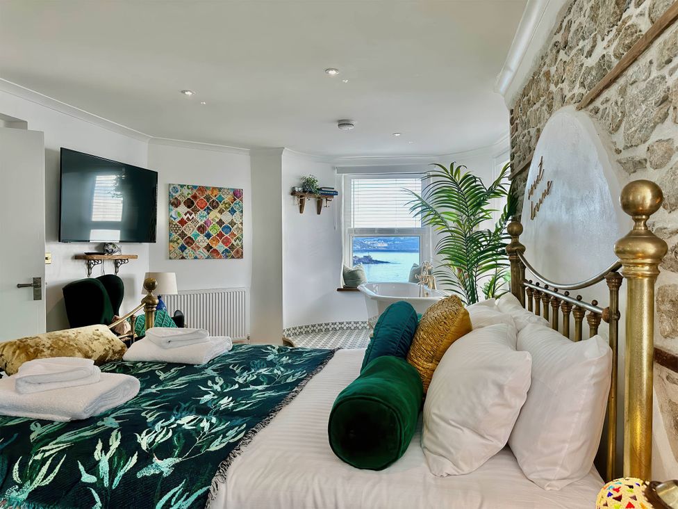 A bedroom with a bed and a view of the sea at The Old Barn in Manchester