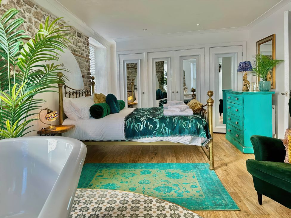 A bedroom with a bed and mirrors at the property name in location