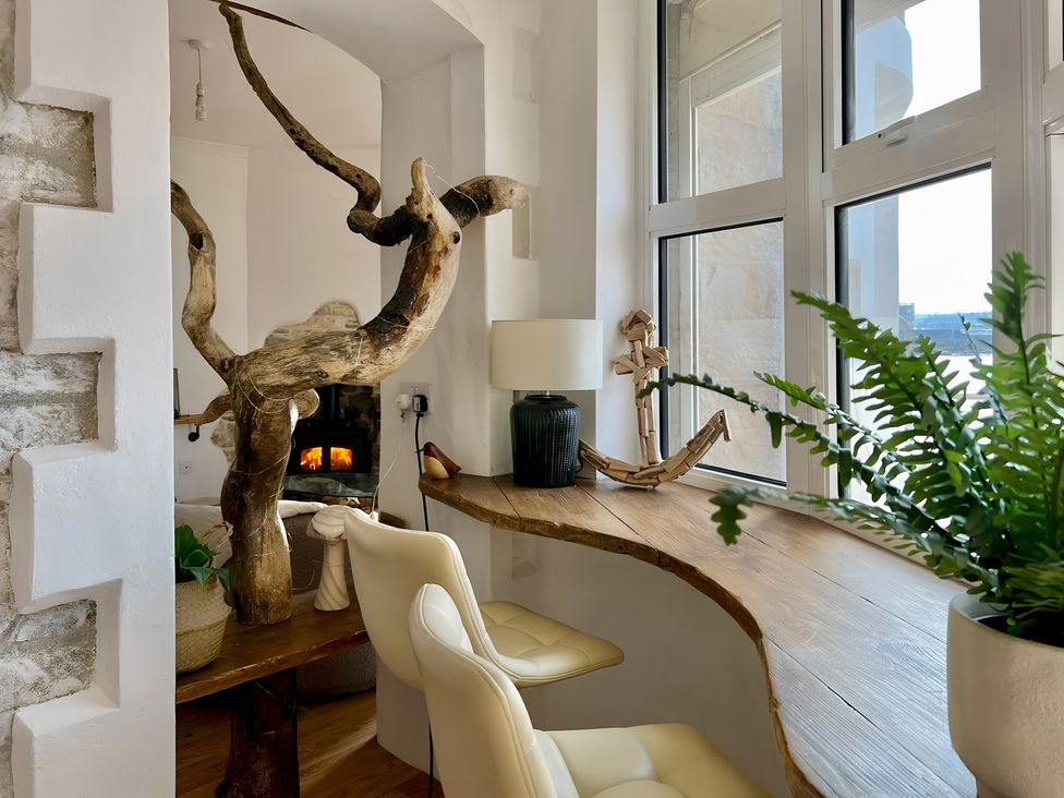 A sitting area with a wooden table and chairs at Seafront Cottage