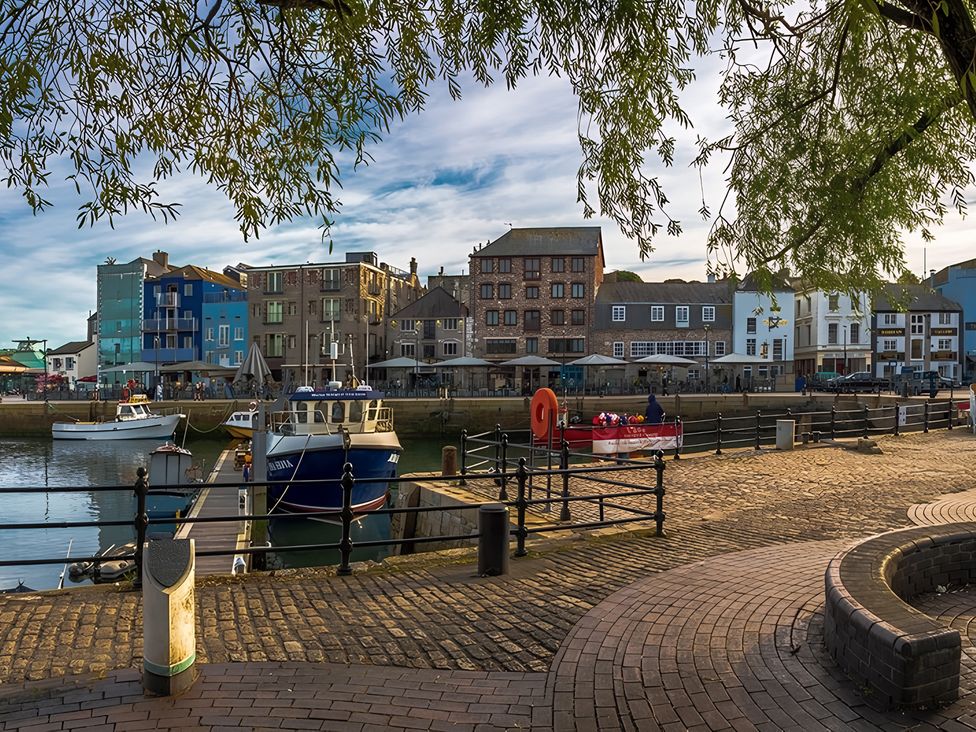A waterfront scene with boats and buildings near the dock at Seafront Cottage in 