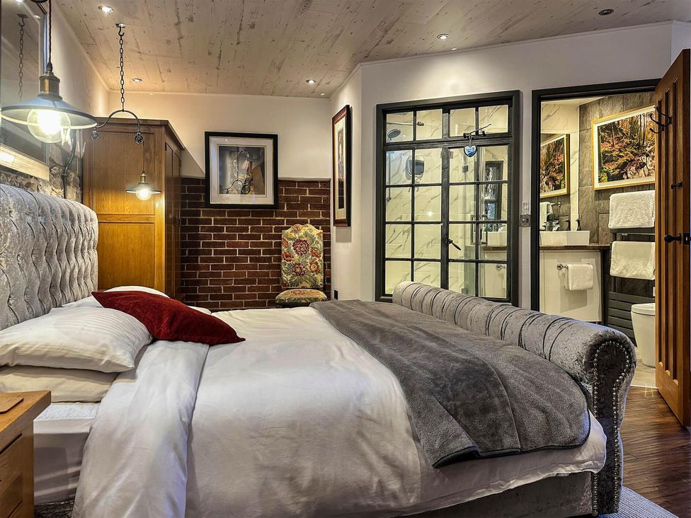 A bedroom with a bed and an adjoining bathroom at The Old Barn in Manchester