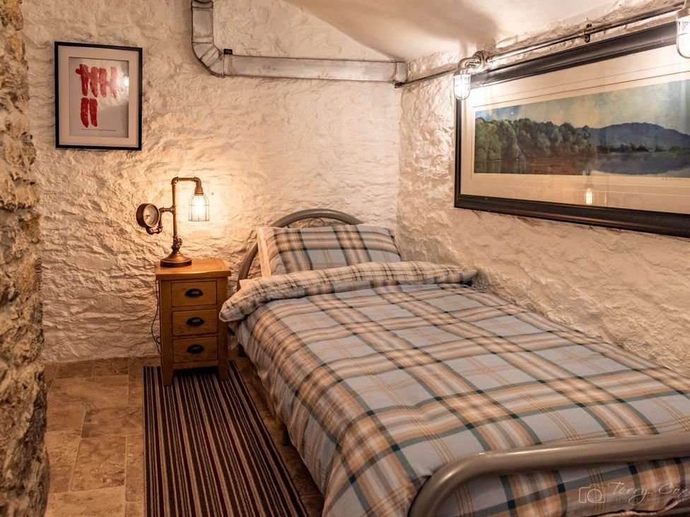 A bedroom with a bed and nightstand at The Old Barn in Manchester