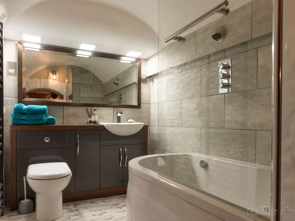 A bathroom featuring a sink, toilet, bathtub and mirror