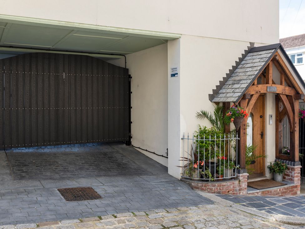 A garage and entrance with plants and a fence at The Old Barn in Manchester