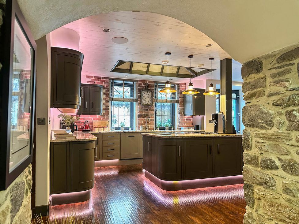 A kitchen with an island and cabinets at The Old Barn in Manchester