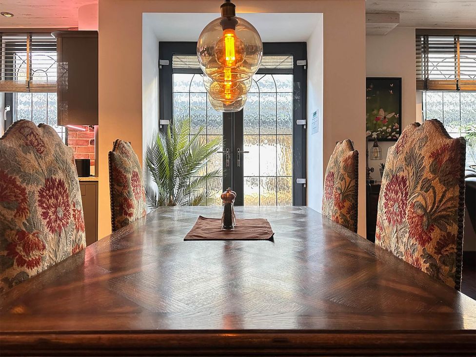 A dining room with a wooden table and chairs at The Old Barn in Manchester