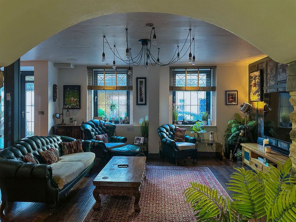A living room with a sofa, coffee table, and plants at the property in location