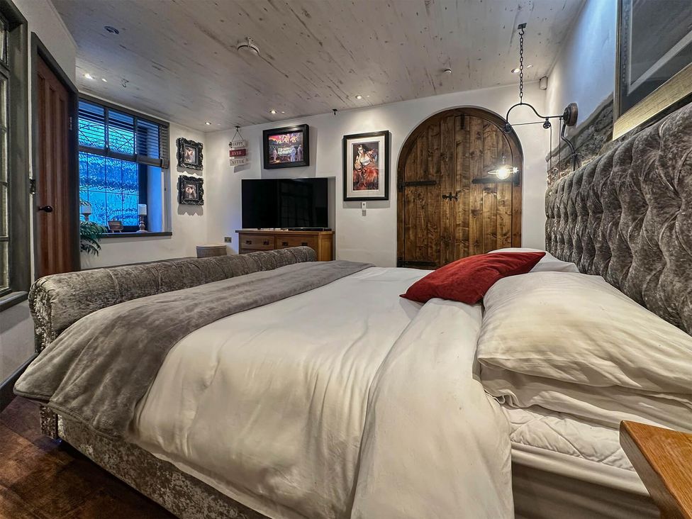 A bedroom with a bed and a television at The Old Barn in Manchester