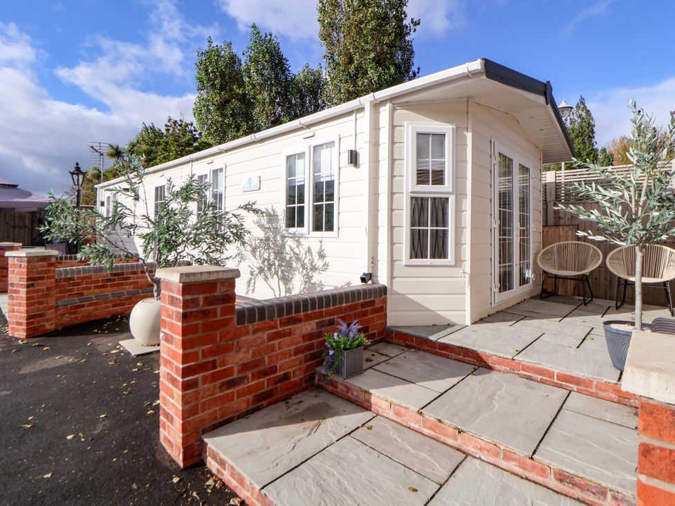 An outdoor area with a house and seating at Lodge in Talacre