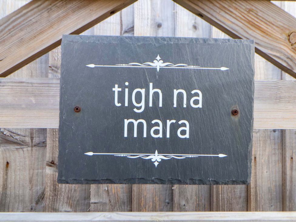 A slate sign reading tigh na mara on a wooden fence at Lodge Talacre