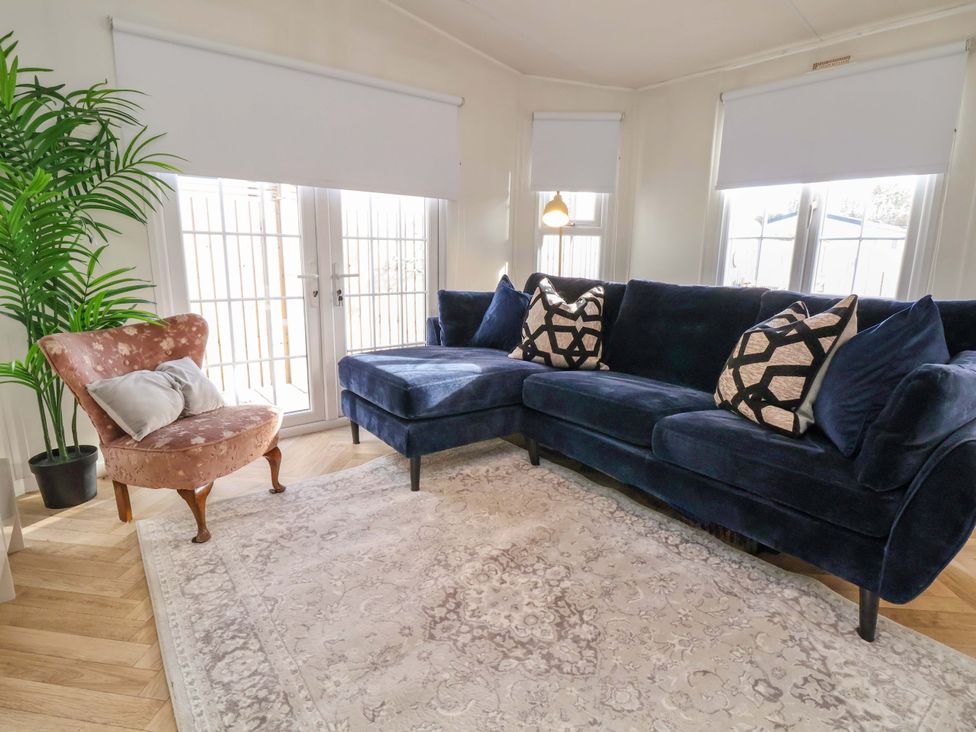 A living room with a sofa and a chair at Lodge in Talacre