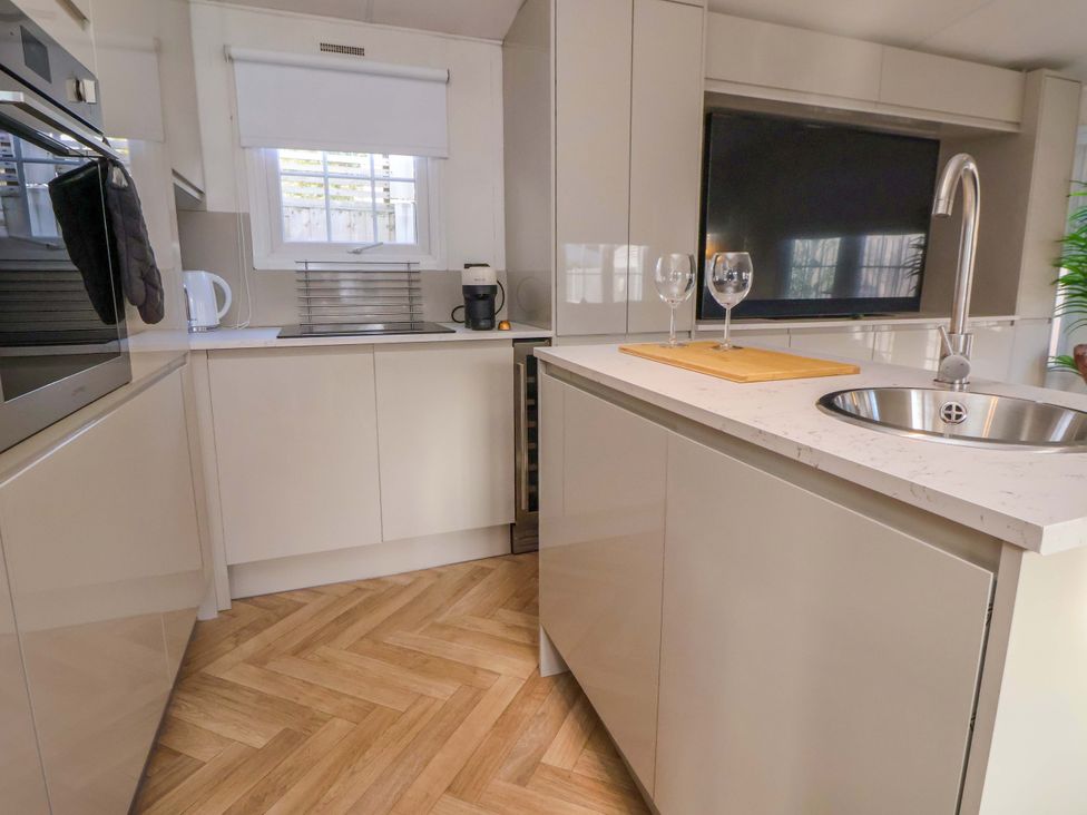 A kitchen with a sink and cutting board at Lodge in Talacre