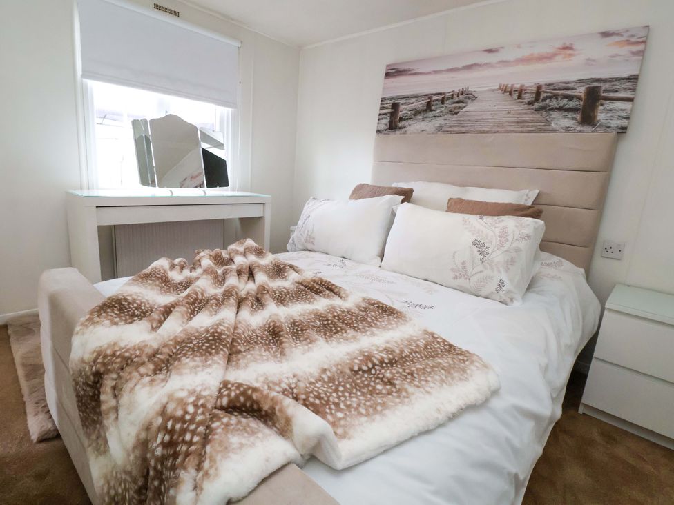 A bedroom with a bed and decor at Lodge in Talacre
