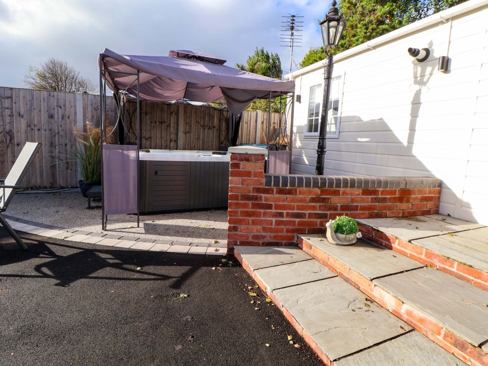 An outdoor area with a hot tub and gazebo at Lodge in Talacre
