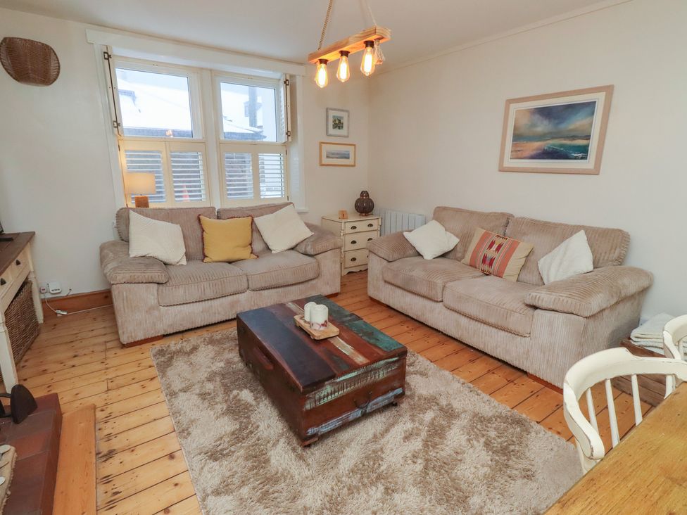 A living room with two sofas, a coffee table and a lamp at Corner Cottage in Seahouses