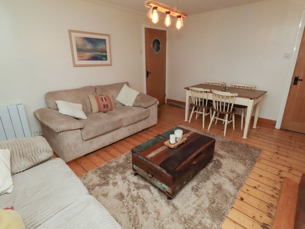 A living room with a sofa and dining table at Corner Cottage in Seahouses