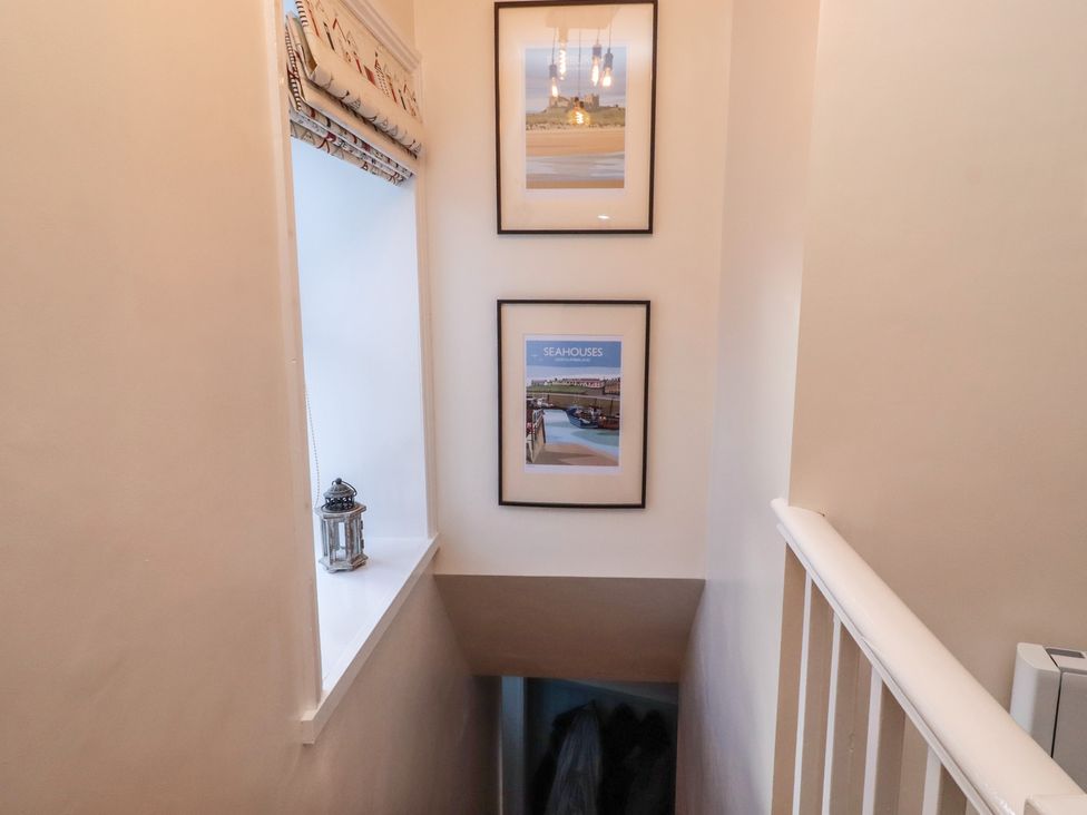 A hallway with photos and a lantern at Corner Cottage in Seahouses