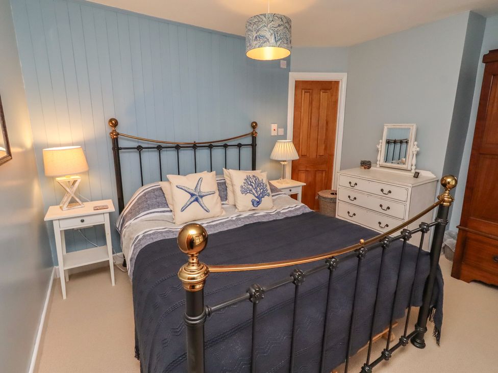 A bedroom with a bed and nightstand at Corner Cottage Seahouses