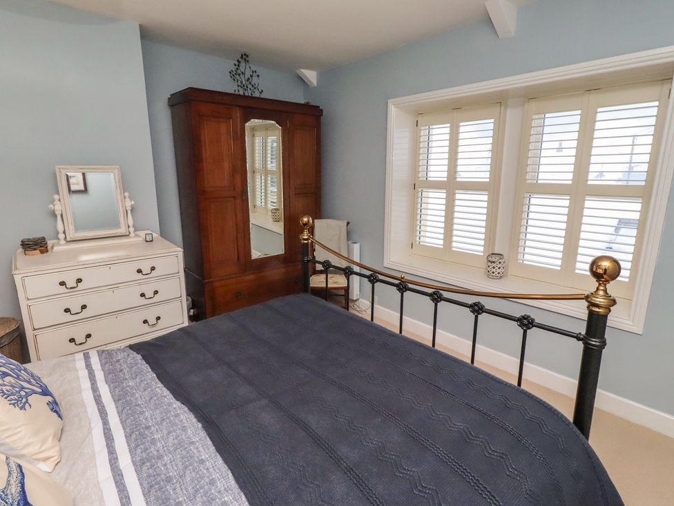 A bedroom with a bed and wardrobe at Corner Cottage Seahouses