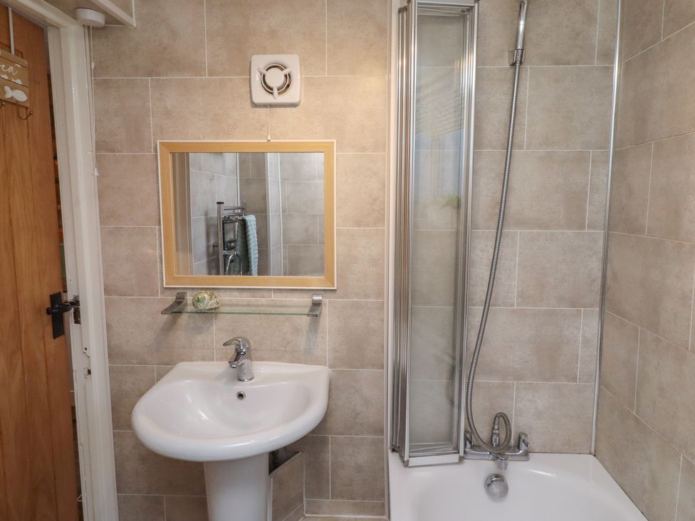 A bathroom with a wash basin and shower at Corner Cottage Seahouses