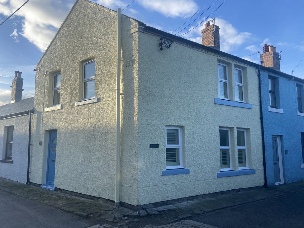 A house with blue and yellow facade at Corner Cottage in Seahouses