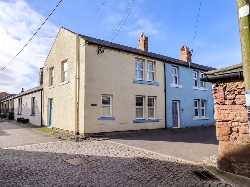 An exterior view of a street with residential houses at Corner Cottage in Seahouses