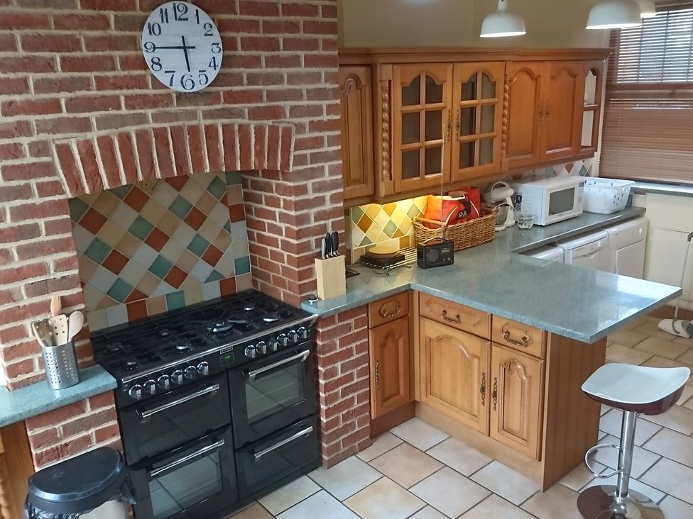 A kitchen with wooden cabinets and a gas stove at 55 Egerton Road