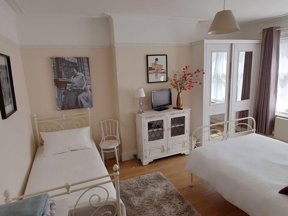 A bedroom with two beds and a cabinet at 55 Egerton Road